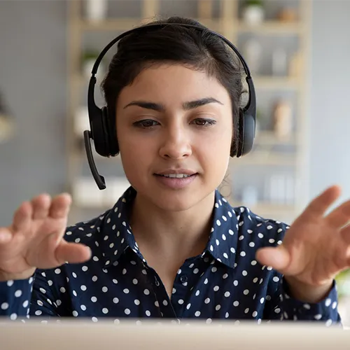 young woman wearing headset in front of laptop